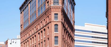 A corner building with a brick facade, large windows, and a visible entrance.