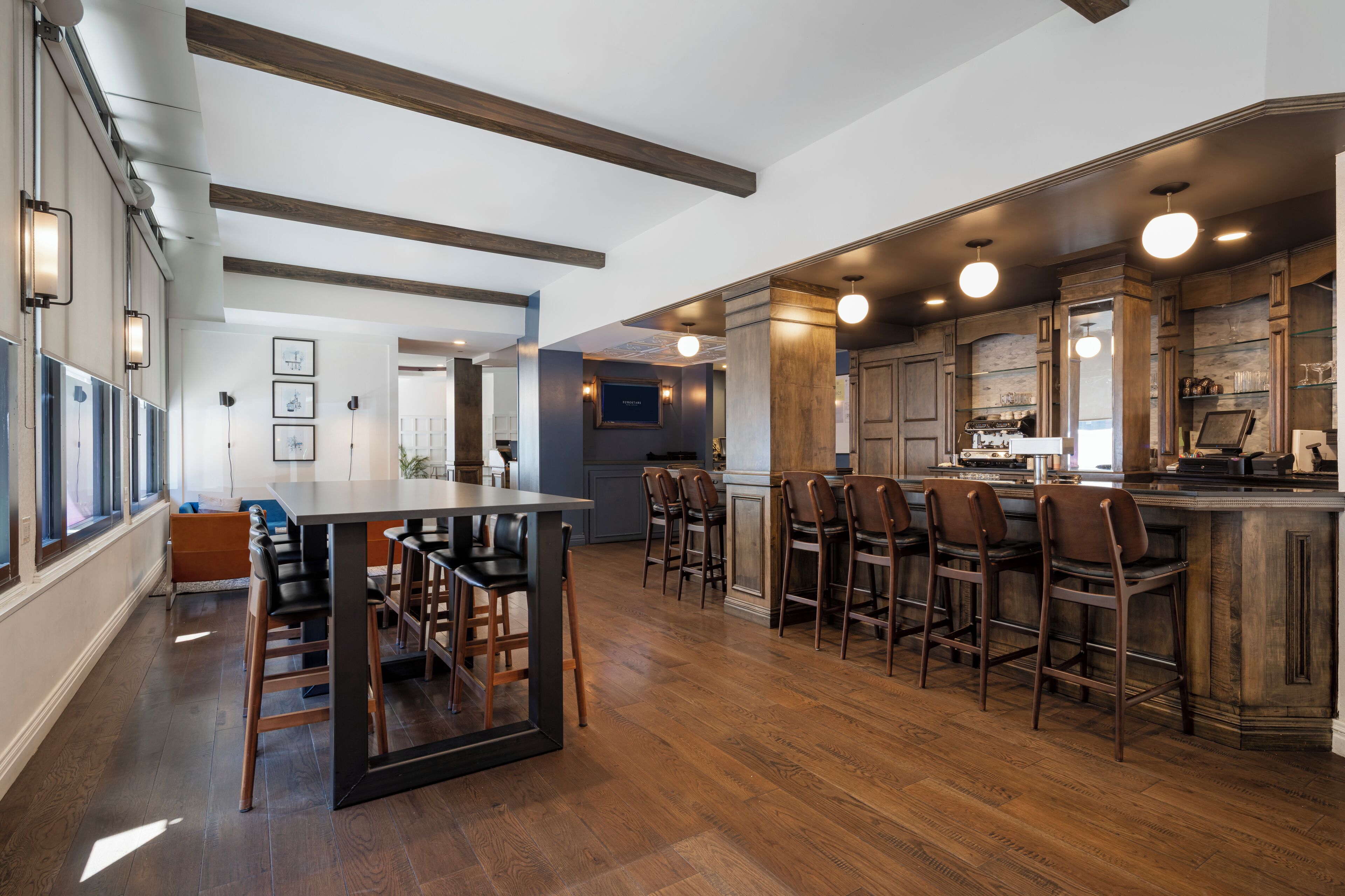 A spacious kitchen with a central island, bar stools, and a dining area with a table and chairs.