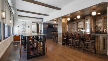 A spacious kitchen with a central island, bar stools, and a dining area with a table and chairs.