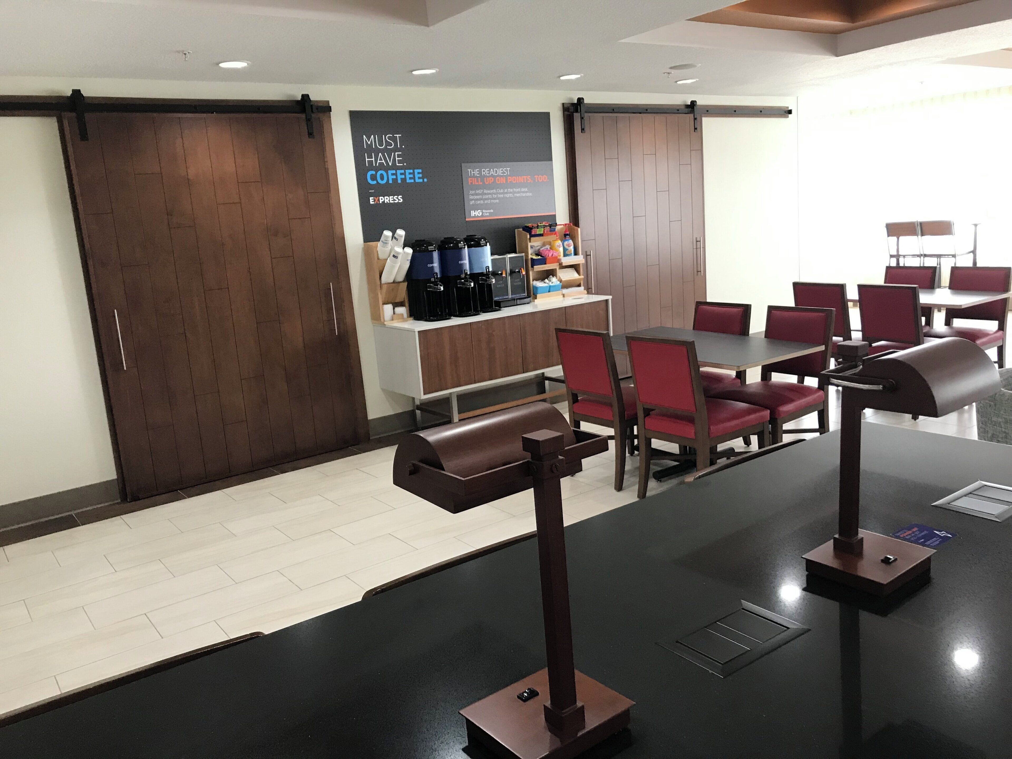 A modern coffee shop with a counter, seating area, and a coffee machine.