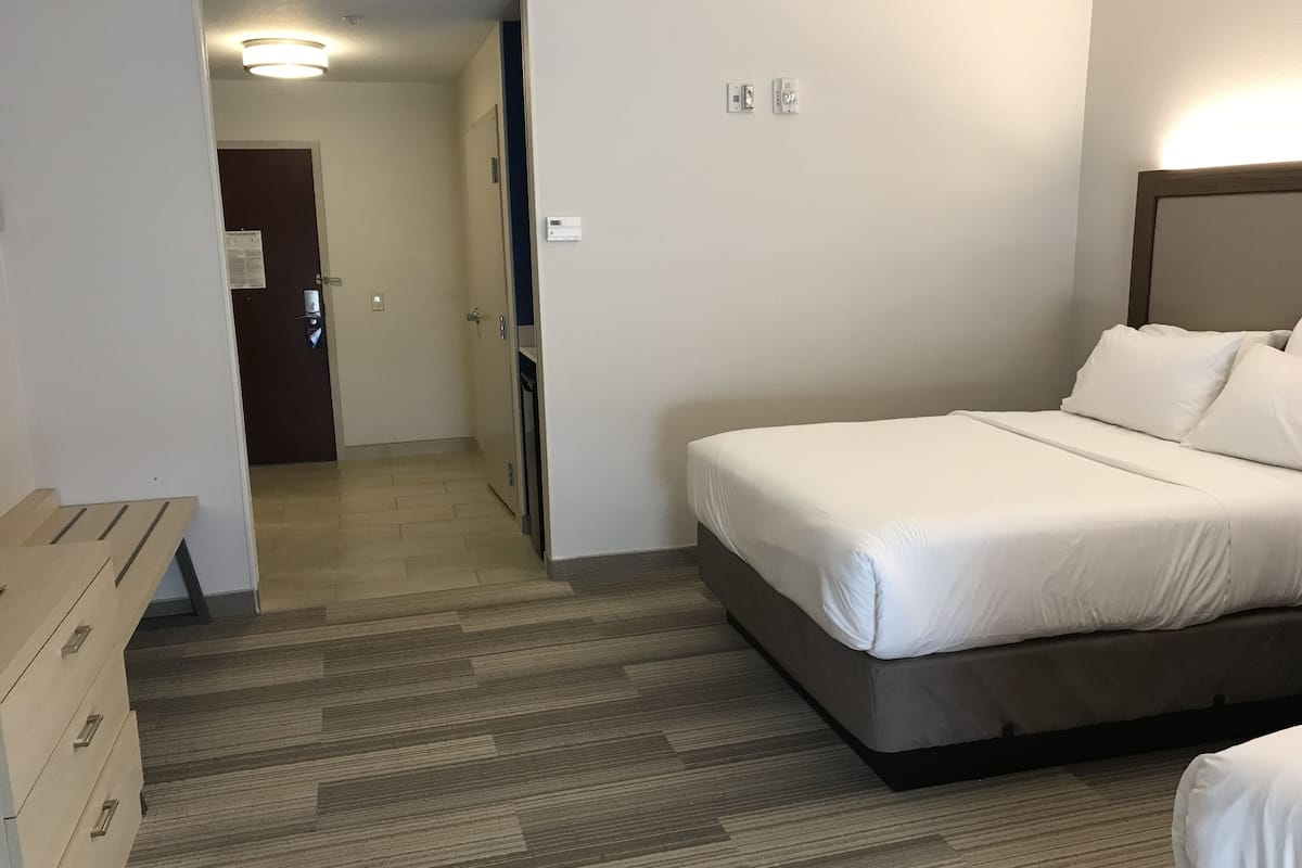 Ett hotellrum med en säng, ett skrivbord och en garderob.