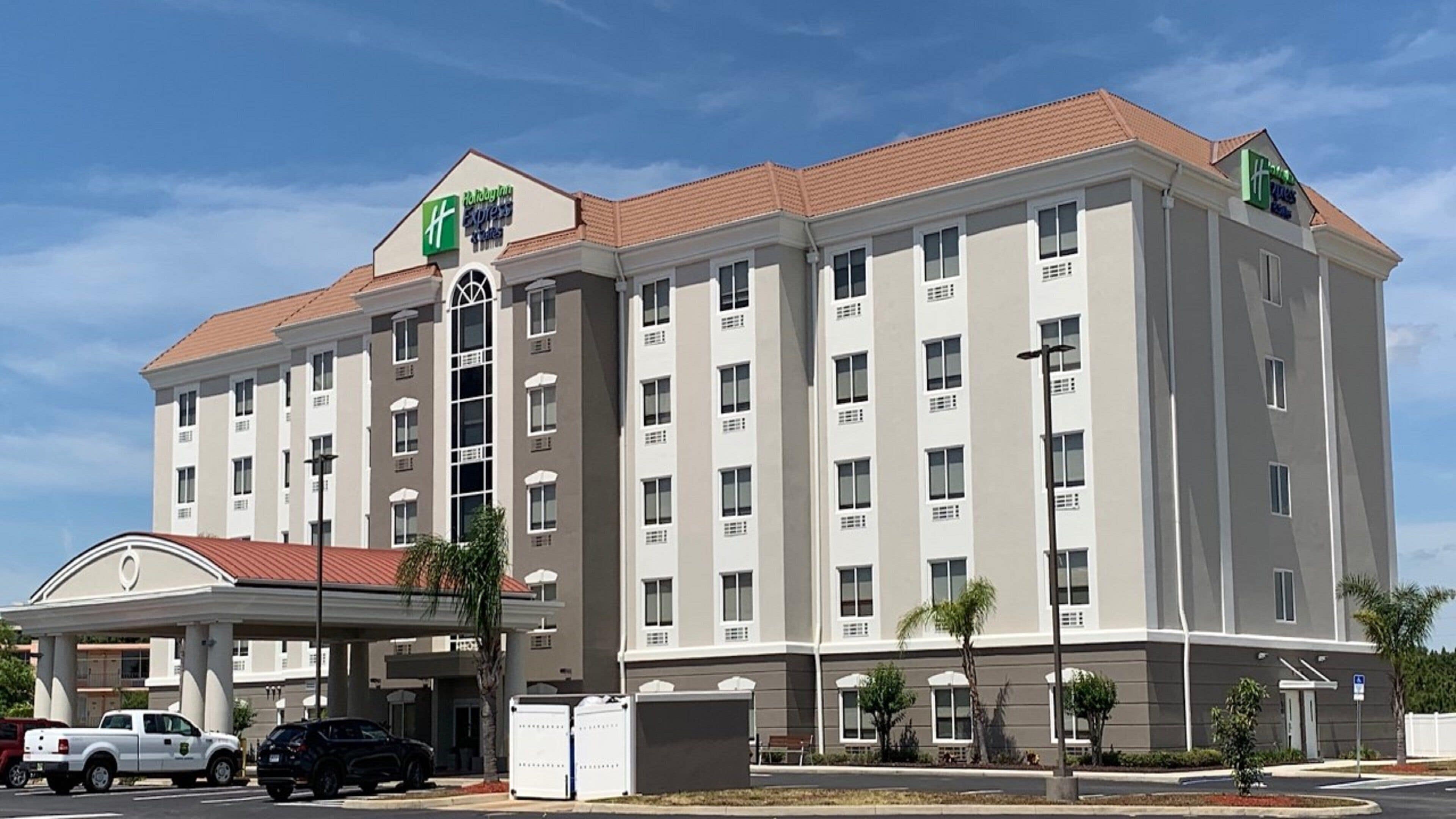 A multi-story hotel with a central courtyard, a covered parking area, and a sign for a Holiday Inn Express.