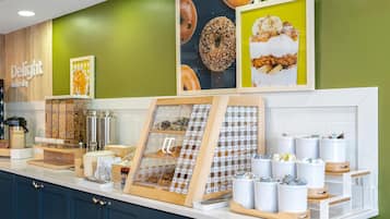 Una barra de desballestament amb una màquina de cafè, un quadre amb pastissos i una presentació d'aliments.