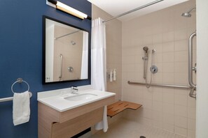 Une salle de bain moderne avec un lavabo blanc, un miroir et une douche.
