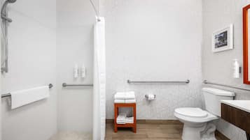 A modern bathroom with a shower, toilet, and vanity.