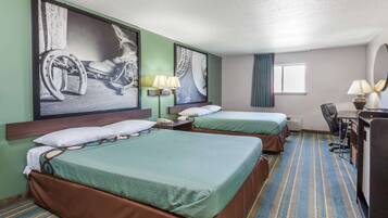 A hotel room with two beds, a desk, a chair, and artwork on the walls.