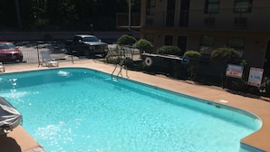 Une piscine rectangulaire à l’eau d’un bleu limpide, entourée d’une terrasse en béton.