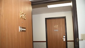 Entrada d'una habitació d'hotel amb una porta de fusta amb el número 107.
