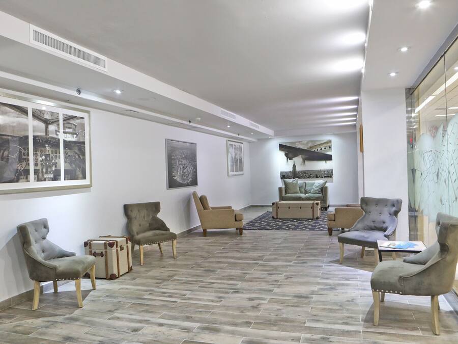 Un hall espacioso con techo alto, mobiliario moderno y obras de arte en las paredes.