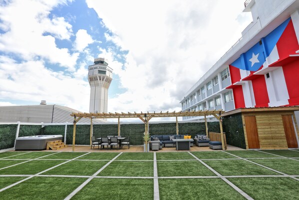 A rooftop patio with a pergola, outdoor seating, and a view of a tower.