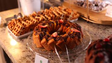 A dessert display with waffles and a bundt cake on a marble countertop.