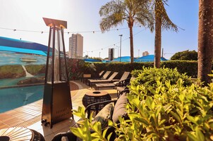 Una piscina al aire libre, sombrillas, tumbonas