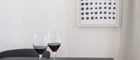 A dining table with two wine glasses, a bowl of chips, and a book.