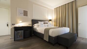 Une chambre d’hôtel équipée d’un lit, d’une table de chevet, d’une lampe et d’un petit réfrigérateur.