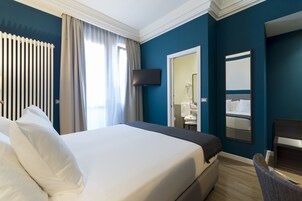 Hotelkamer met een groot bed, een aan de muur bevestigde televisie, een spiegel en uitzicht op de badkamer.