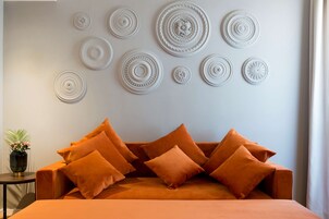 Een kamer met een bank en decoratieve wandkunst.