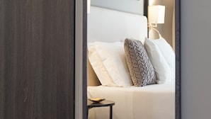 A bedroom with a bed, a bedside table, a lamp, and framed pictures on the wall. - Elizabeth Lifestyle Hotel (Bologna)
