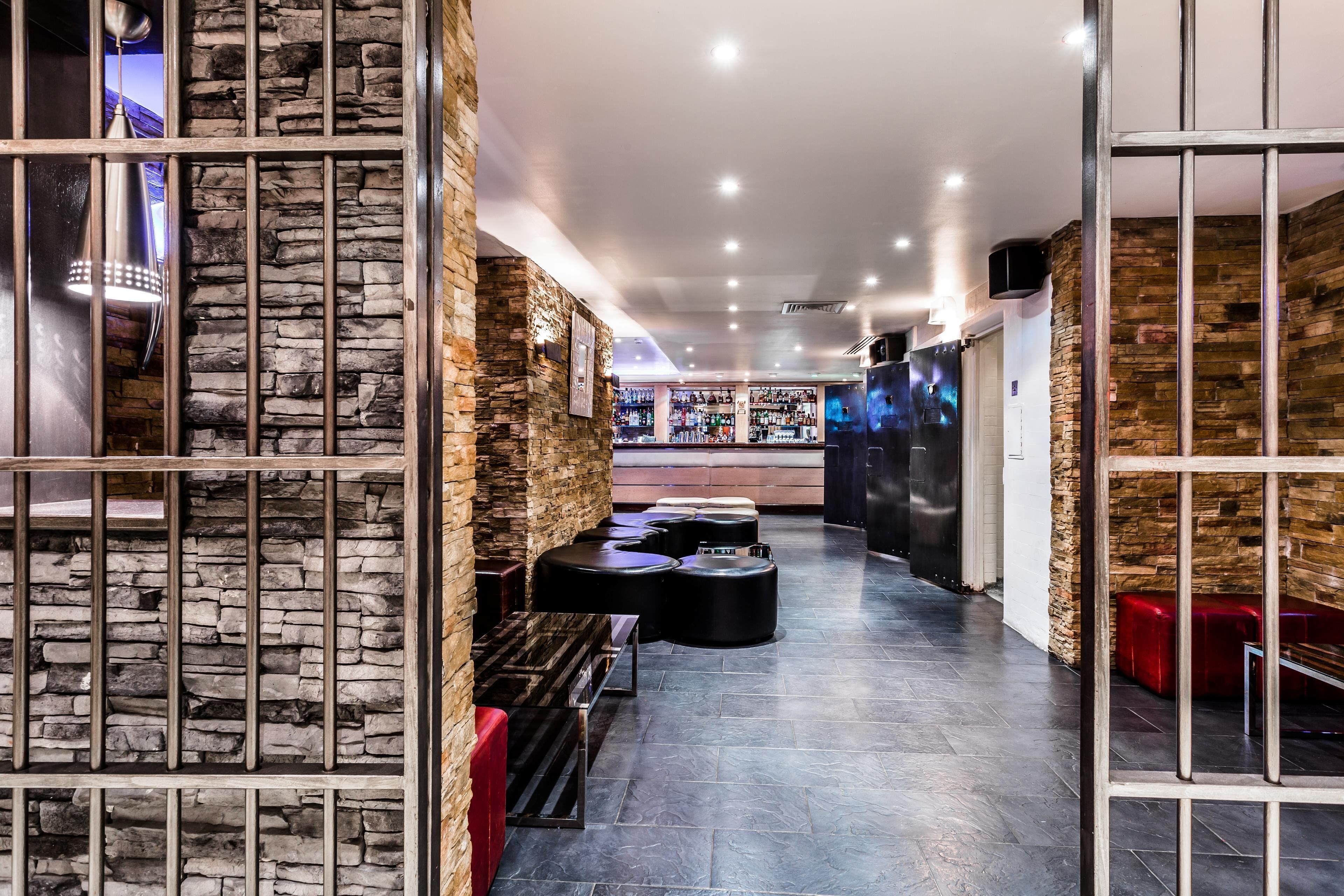 Un interior moderno con paredes de piedra, una zona de bar y asientos.