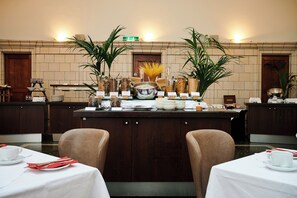 A hotel lobby with a reception desk, chairs, tables, and potted plants. - Courthouse Hotel (London)