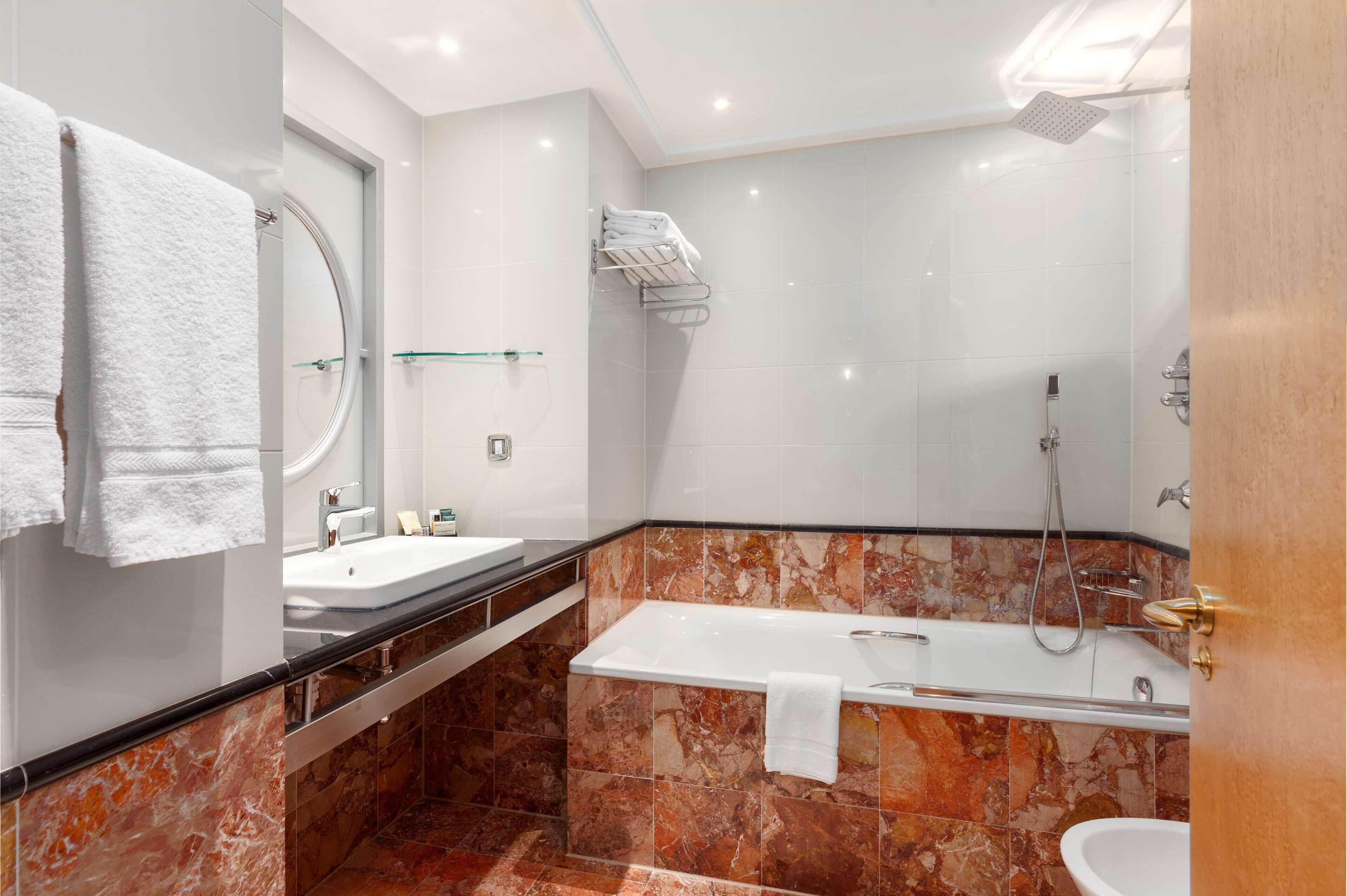 Un bagno moderno con una vasca, una doccia, un lavandino e un water.