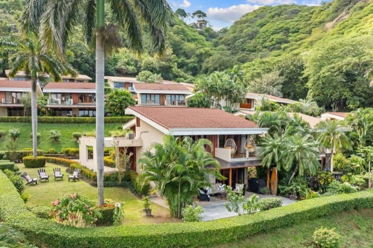 Ein Resort mit mehreren Villen, gepflegten Gärten und einer üppigen, grünen Landschaft.