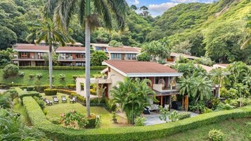 Un resort con varias villas, jardines cuidados y un paisaje verde y exuberante.