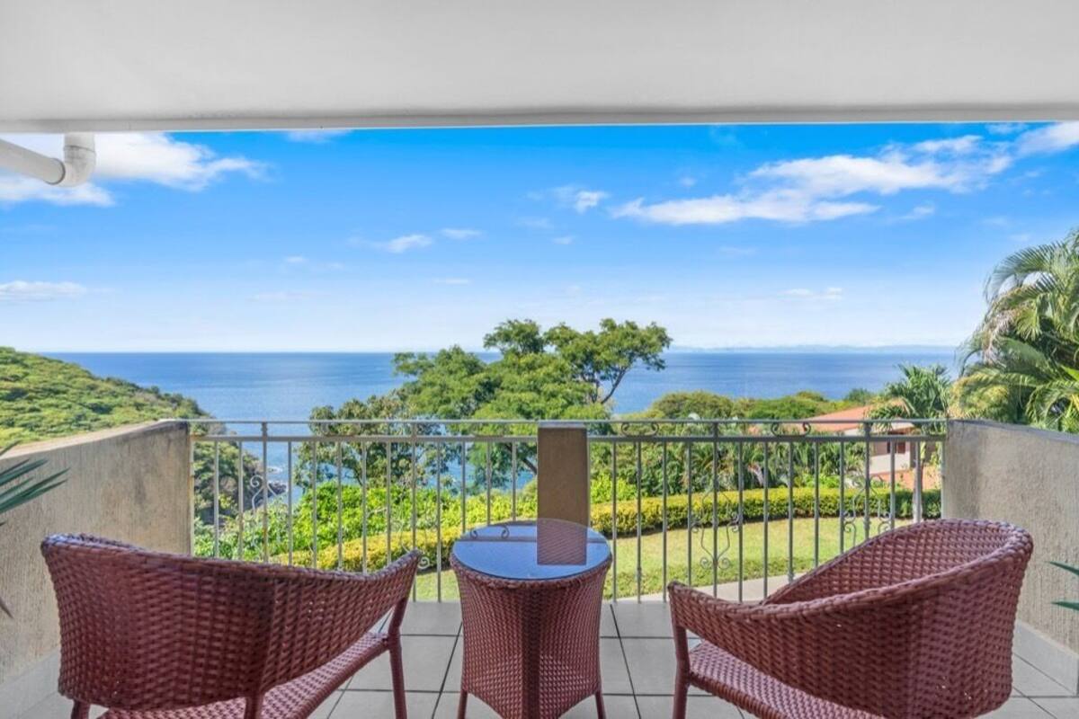Ein Balkon mit Korbmöbeln und Meerblick.