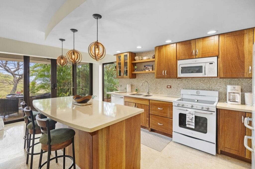 Una cocina moderna con armarios de madera, una isla grande y un horno empotrado.