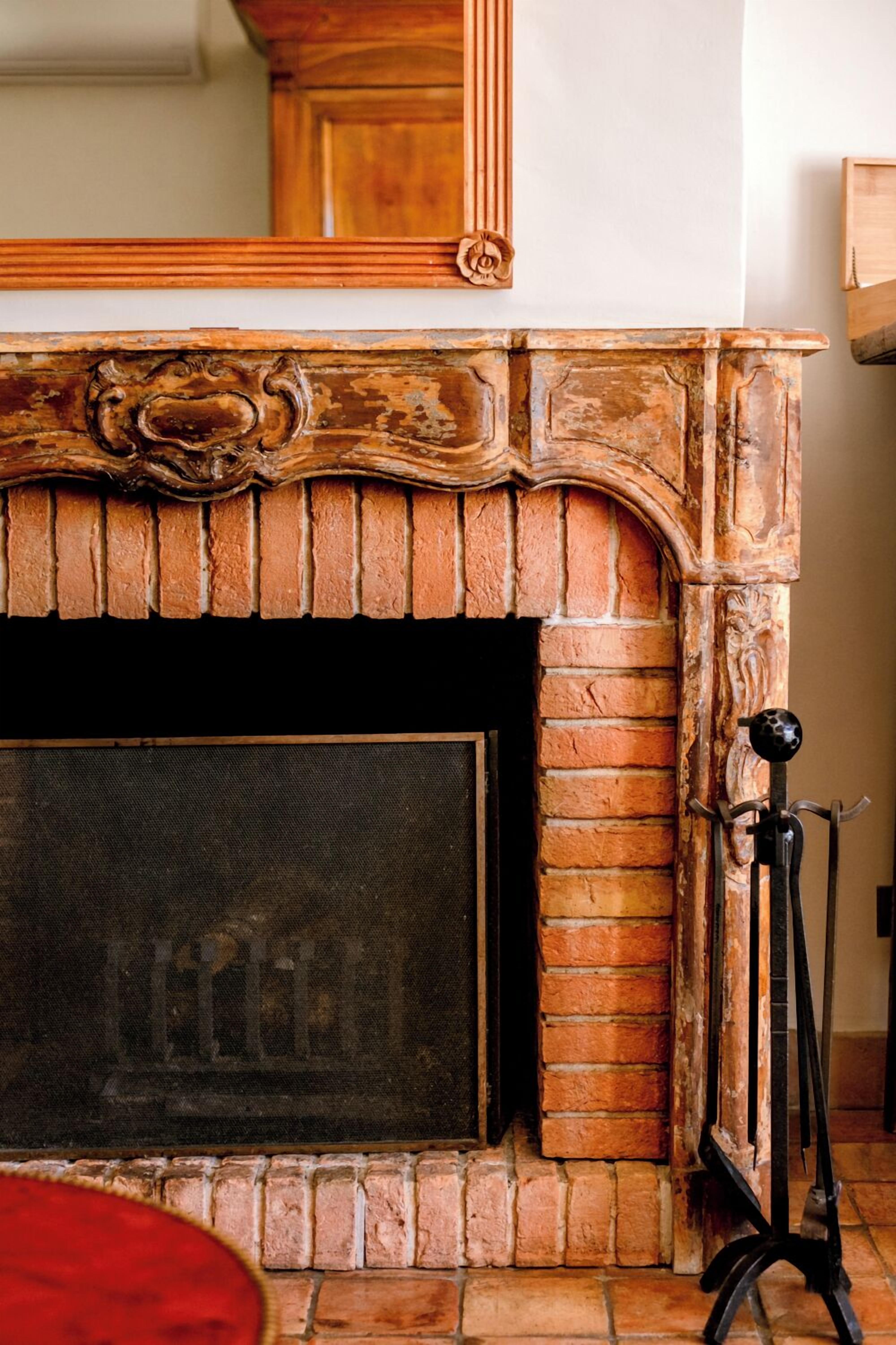 A fireplace with a brick surround and a decorative mantelpiece.