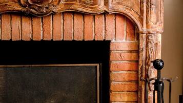 A fireplace with a brick surround and a decorative mantelpiece.