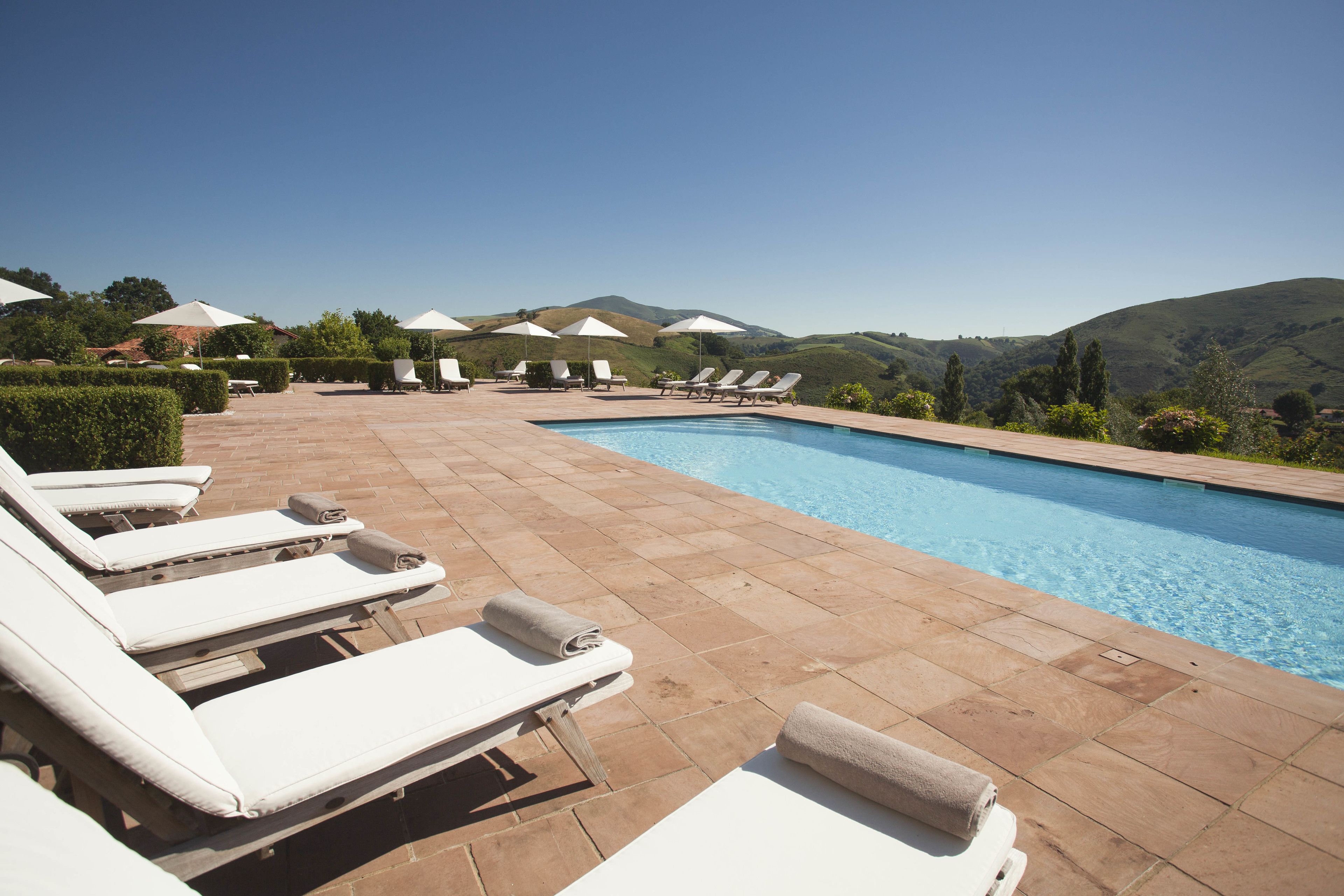 Een seizoensgebonden buitenzwembad en parasols bij het zwembad