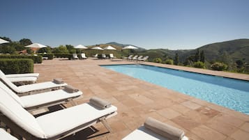 Een seizoensgebonden buitenzwembad en parasols bij het zwembad