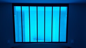 A room with a bed, two bedside tables, and a window with vertical blinds. - Brit Hotel de Grignan (Vichy)