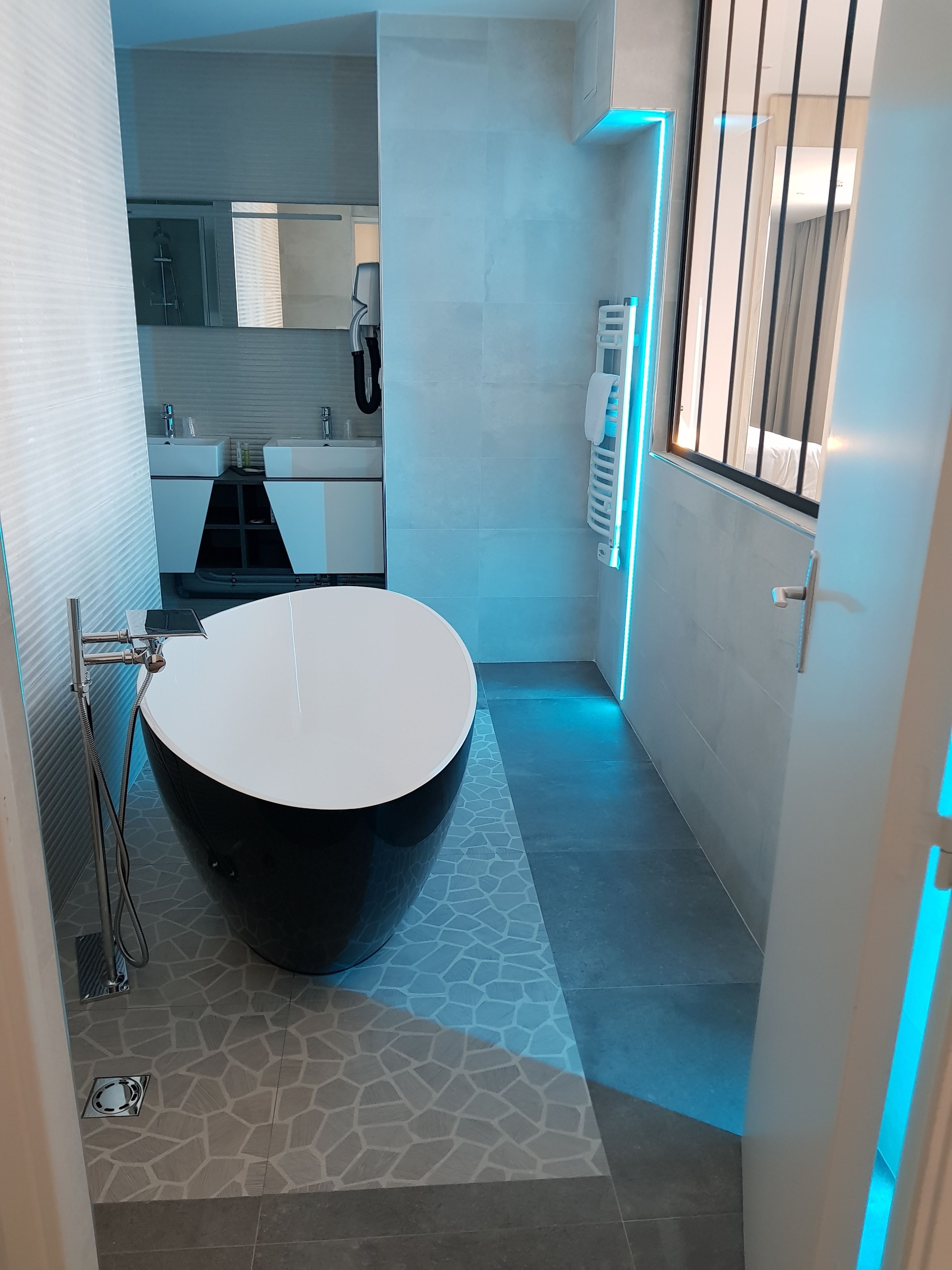 Un baño moderno con una bañera grande, ducha e inodoro.