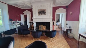 Una habitación con chimenea, zona de estar y comedor.