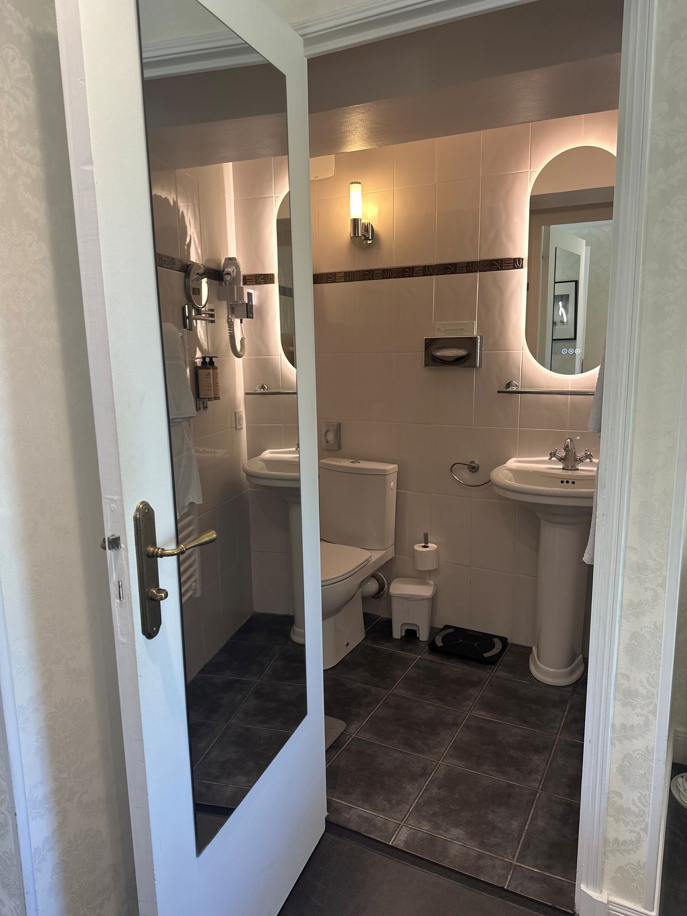 Un baño con inodoro, lavabo y espejo.