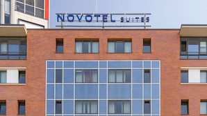 A hotel with a sign reading 'NOVOTEL SUITES' above a modern building facade with a grid of windows. - Novotel Suites Berlin City Potsdamer Platz (Berlin)
