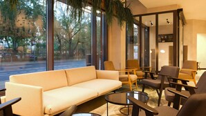 A modern lounge area with a sofa, armchairs, and a coffee table. - Novotel Suites Berlin City Potsdamer Platz (Berlin)