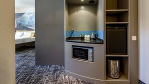 A modern hotel room with a kitchenette, a bed, and a bathroom. - Novotel Suites Berlin City Potsdamer Platz (Berlin)