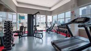 Un gimnasio moderno con cintas de correr, mancuernas y máquinas de pesas.