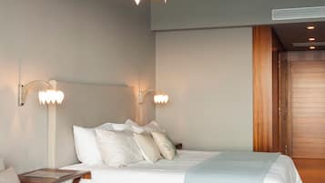 Une chambre moderne avec un lit, des tables de chevet, un canapé et une table basse en bois.
