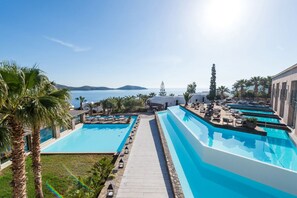 Een resort met diverse zwembaden, een helder uitzicht op de zee en een verzorgde tuin.