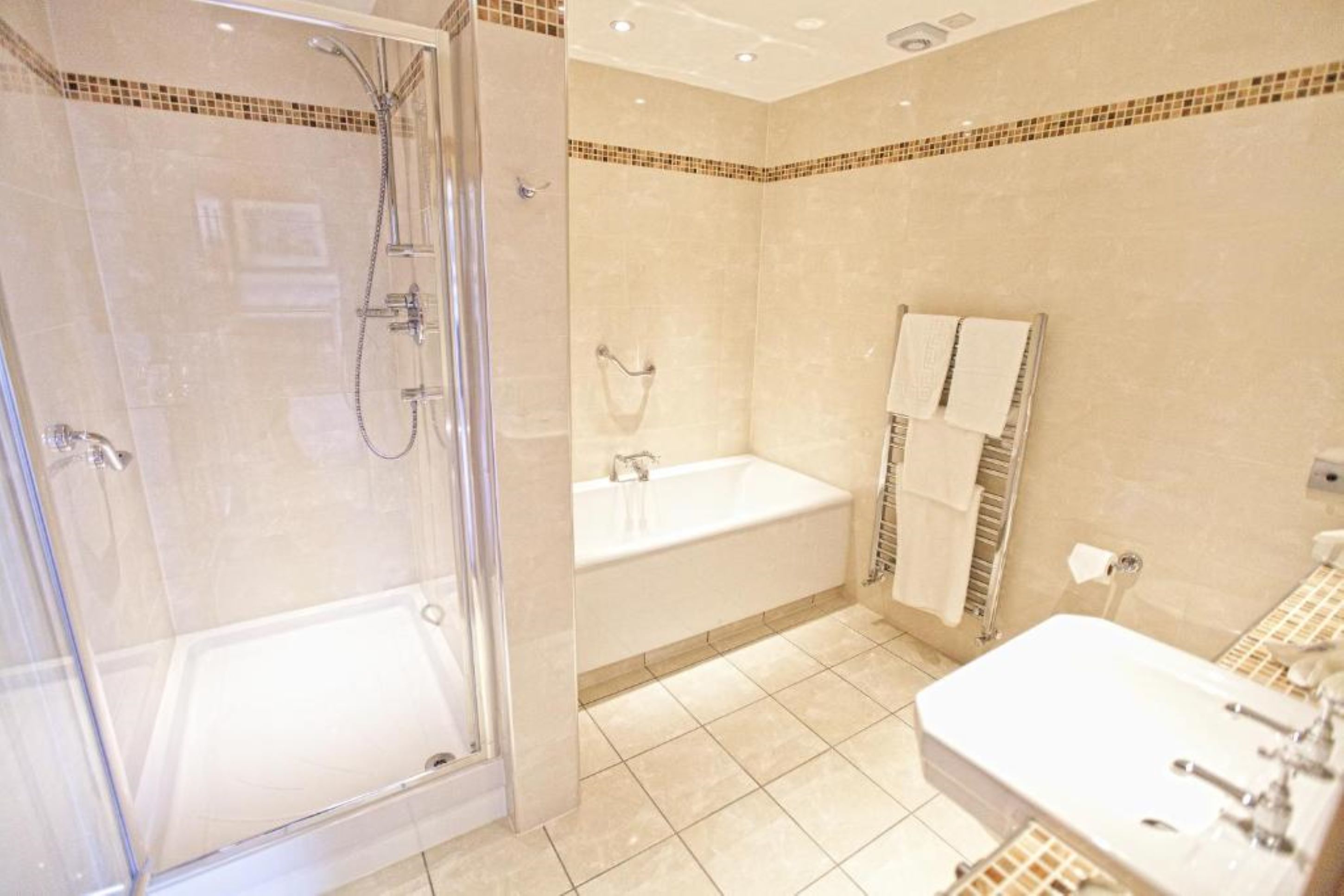 A modern bathroom with a glass-enclosed shower, a standalone bathtub, and a vanity with a sink.