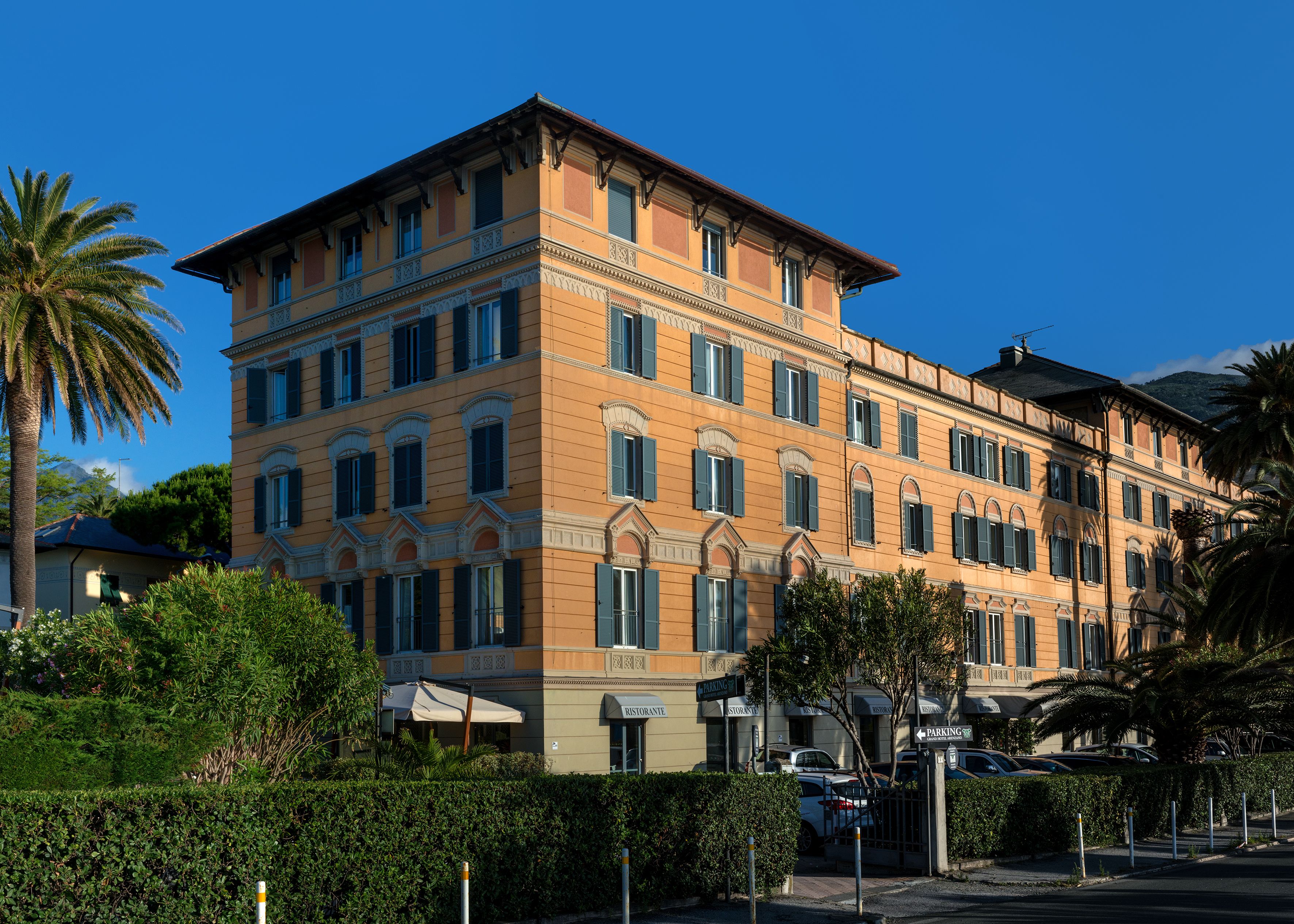 A multi-story building with a classic architectural style, featuring a symmetrical facade, multiple windows with shutters, and a flat roof.