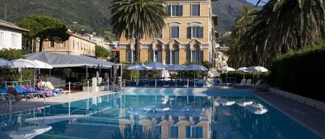 Alberca al aire libre por temporada y sombrillas en la alberca