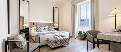Una habitación de hotel moderna con cama, escritorio, silla y sofá.