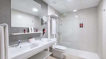 Un baño moderno con lavamanos doble, inodoro y zona de ducha.