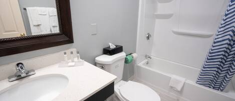 A bathroom with a sink, toilet, and bathtub.
