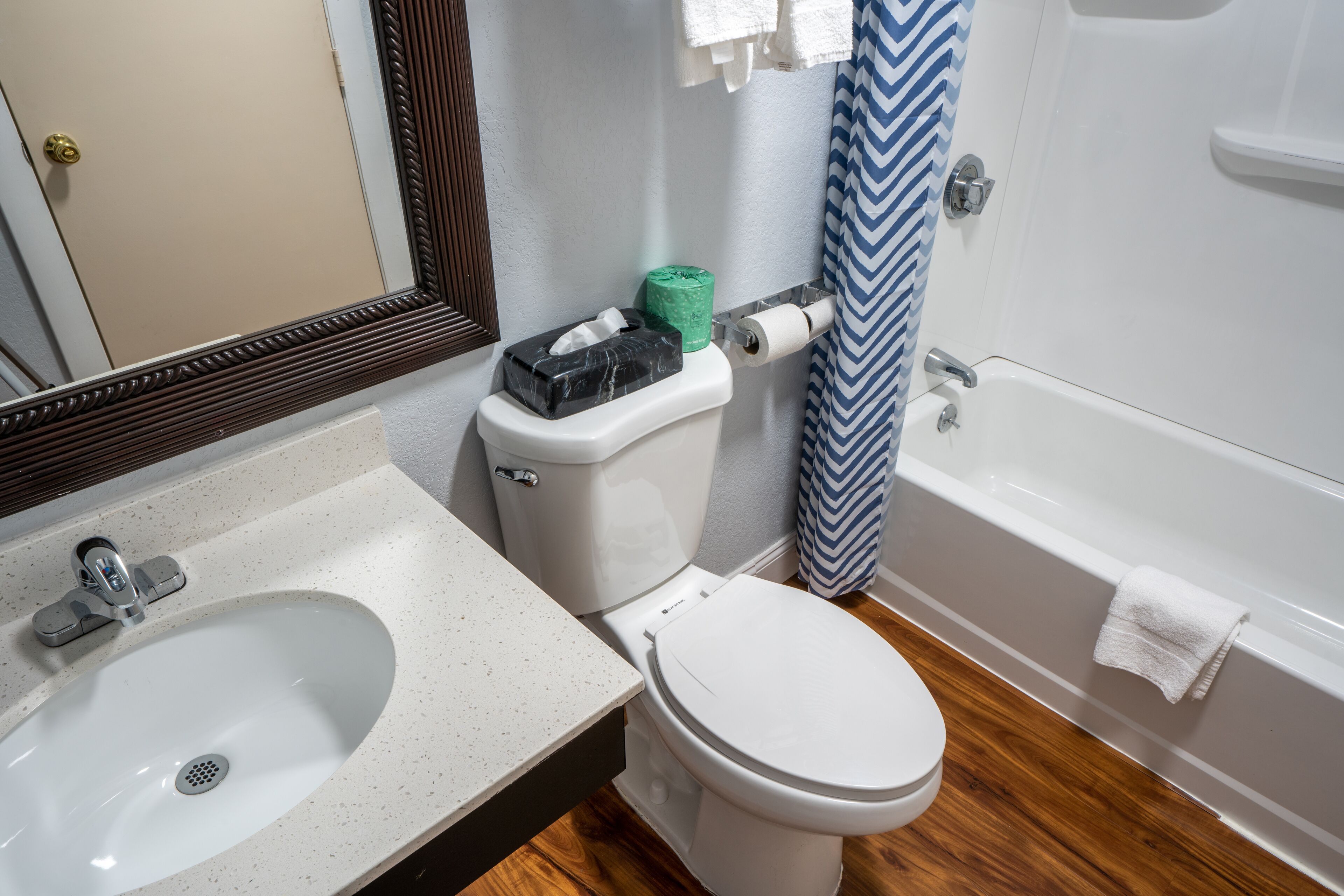 Une salle de bain avec un lavabo, des toilettes et une baignoire, le tout de couleur blanche.