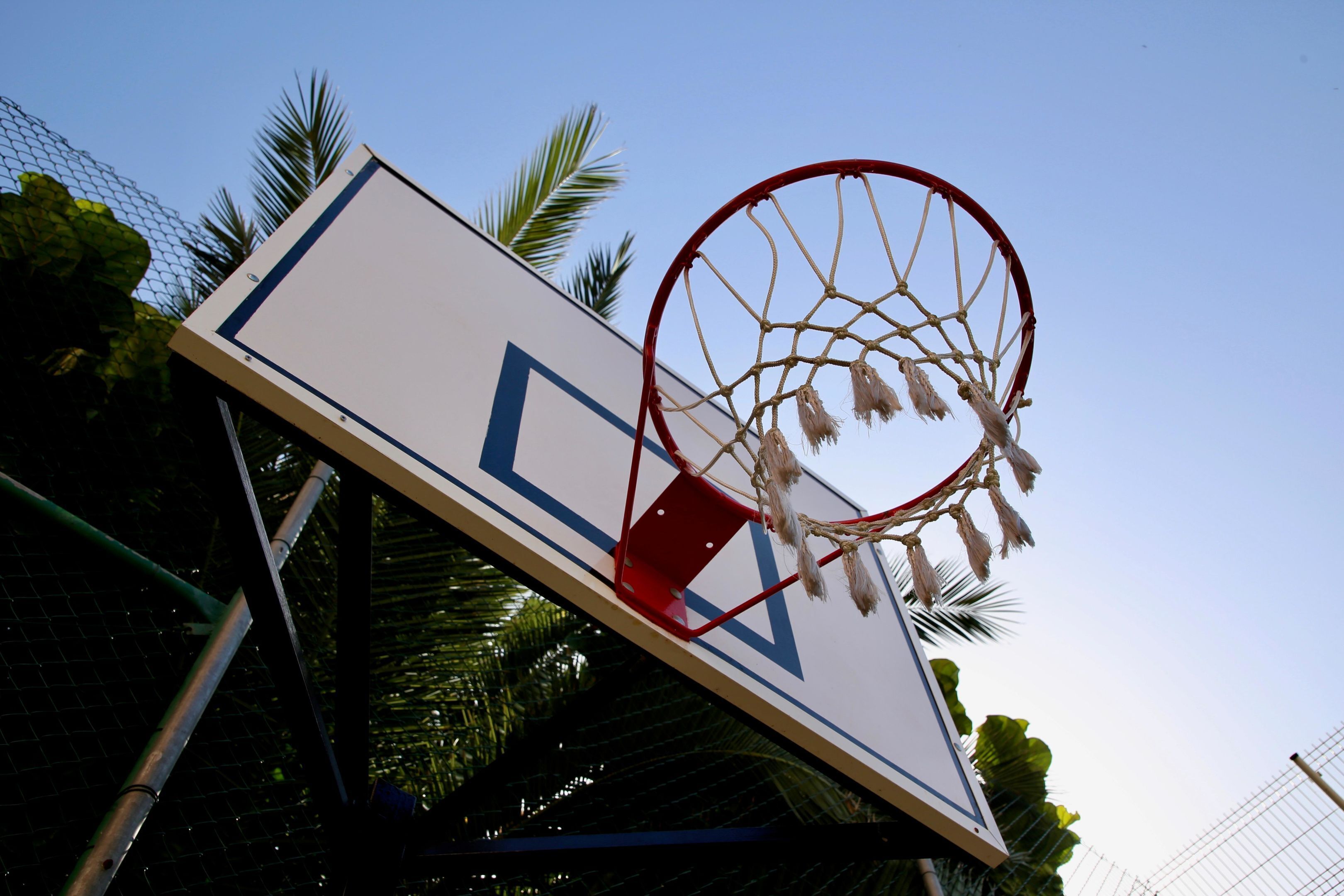 En basketballkurv med net hængt på en væg med geometrisk mønster.
